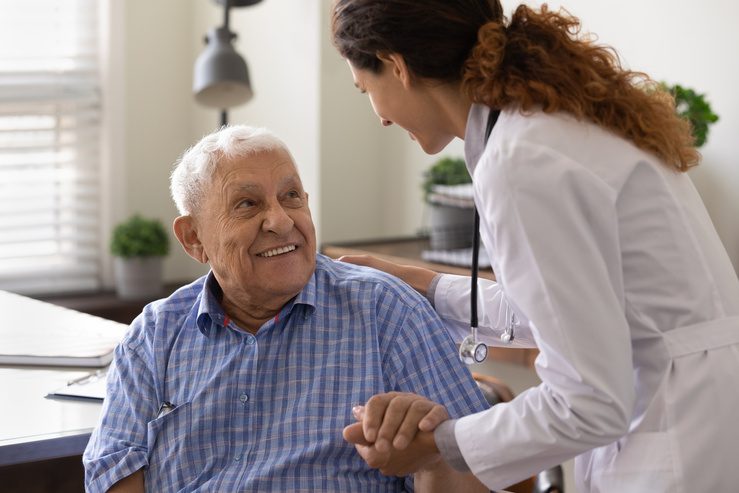Clinic physician speaking with a senior patient during a visit