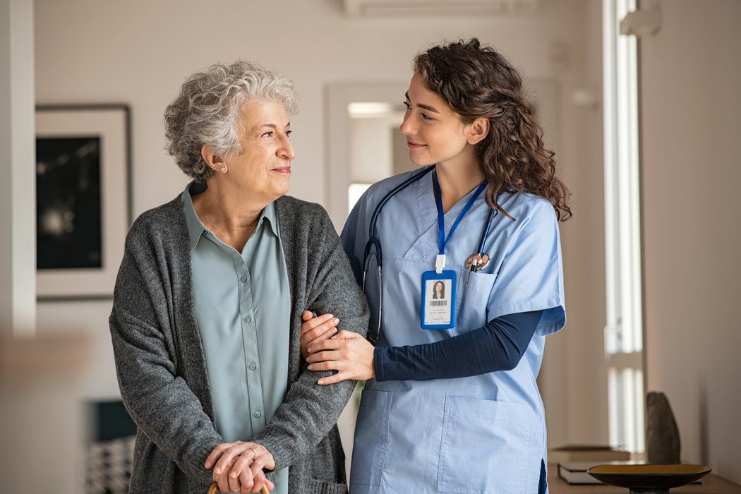Nurse assisting an elderly patient on a hospital unit