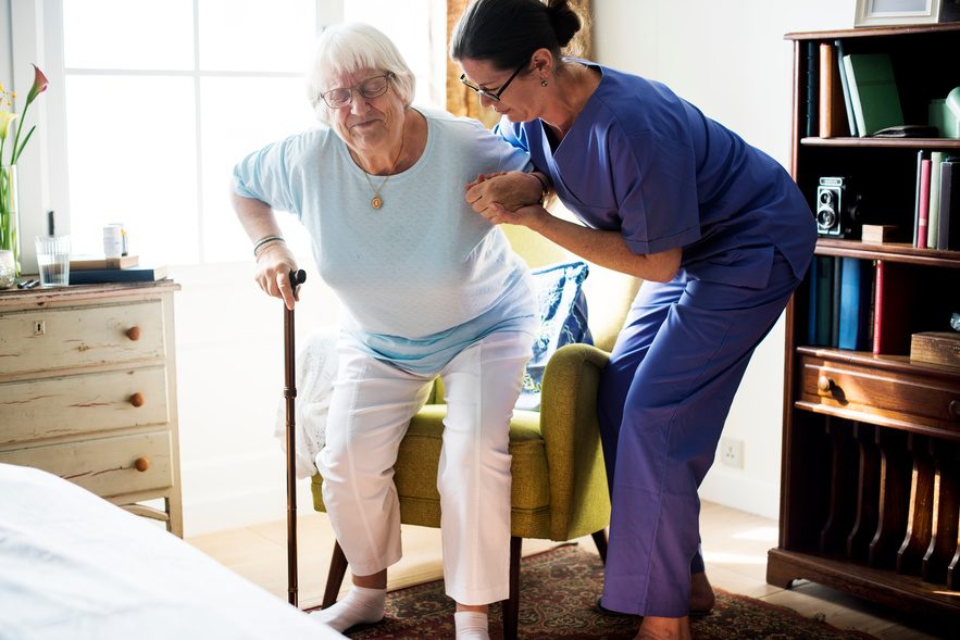 Registered nurse helping a patient with mobility during recovery
