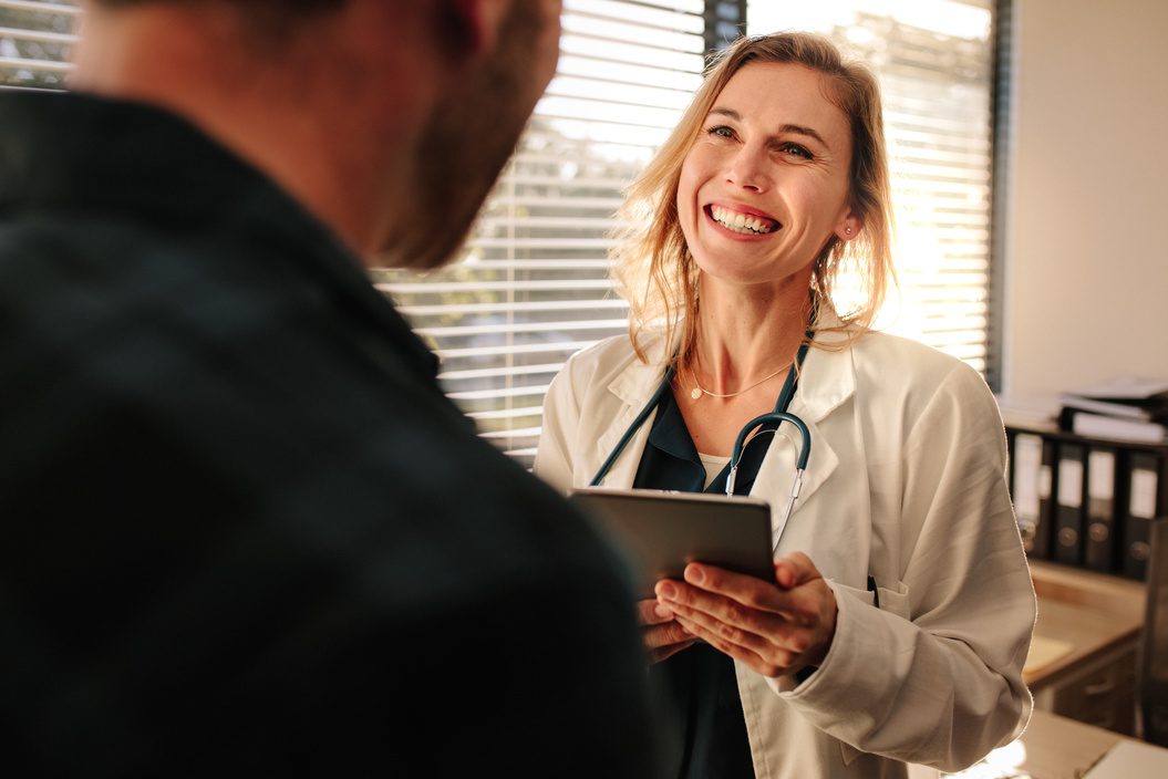 Physician reviewing candidate details on a tablet during a hiring discussion